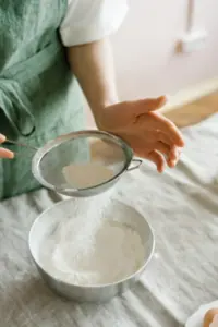 flour being sifted into a bowl
