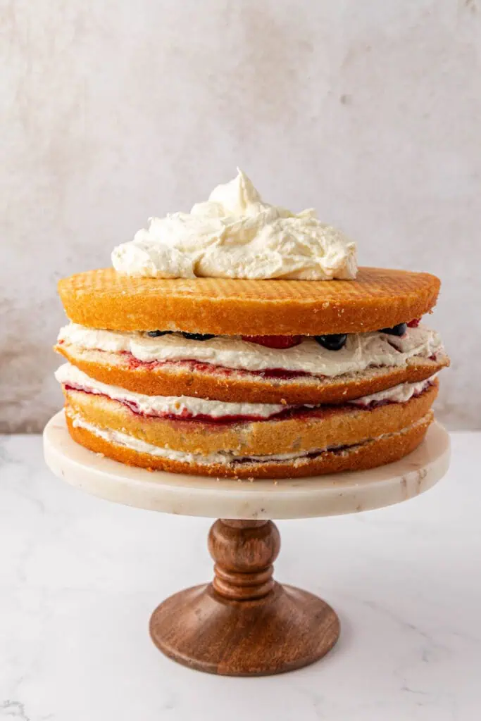 chantilly cake on a cake stand being frosted