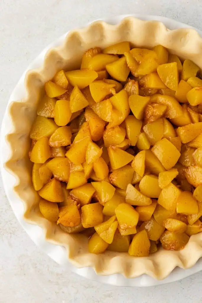 peeled peaches in a pie crust