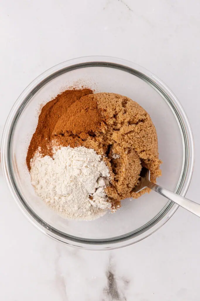 cinnamon, brown sugar, and flour in a bowl with a spoon