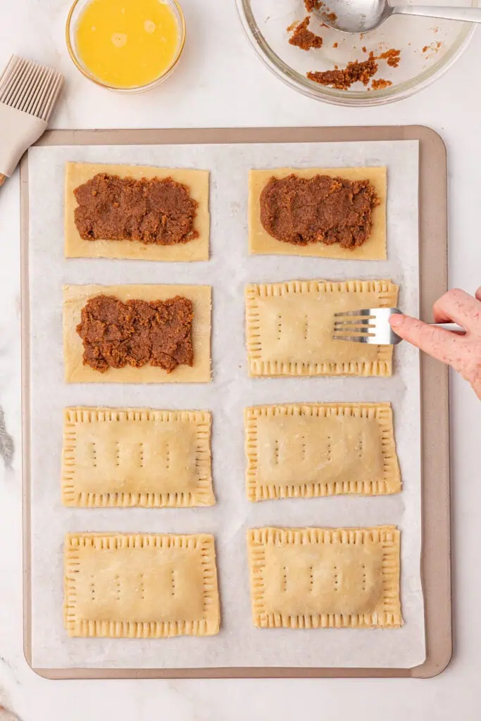 pop tart squares topped with pie crust, sealed with a fork and holes pierced into the top