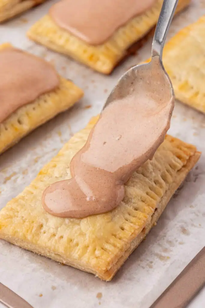 glaze spread onto a pop tart with a spoon