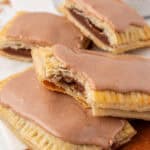 two brown sugar cinnamon pop tarts with one having a bite taken out of it