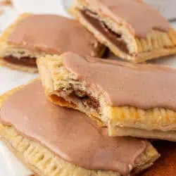 two brown sugar cinnamon pop tarts with one having a bite taken out of it