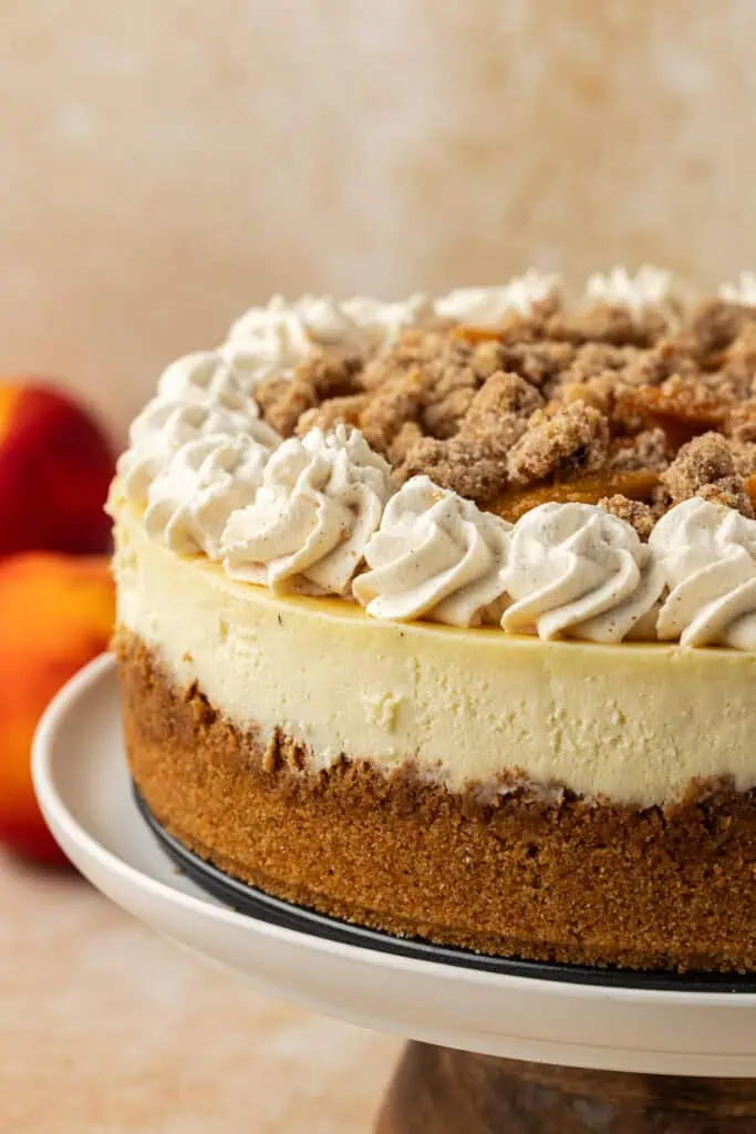 peach crumble cheesecake on a cake stand