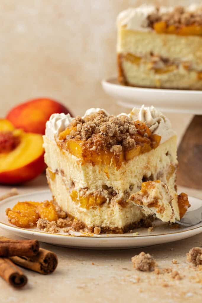 slice of peach crumble cheesecake with forkful missing