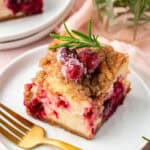 cranberry cheesecake bar on a plate with a fork