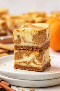 two pumpkin cheesecake bars stacked on top of each other