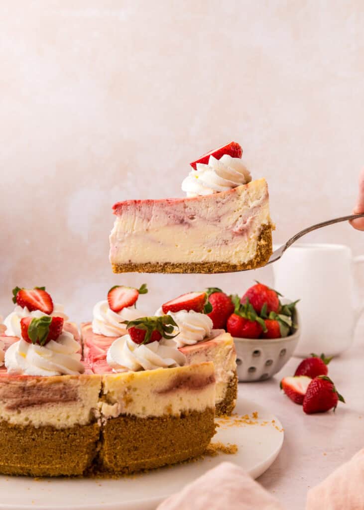slice of cheesecake being pulled away from cheesecake on cake server
