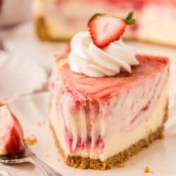slice of strawberry swirl cheesecake with a bite missing