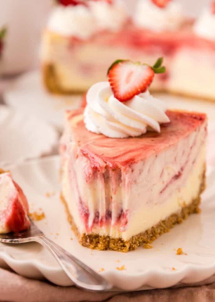 slice of strawberry swirl cheesecake with a bite missing