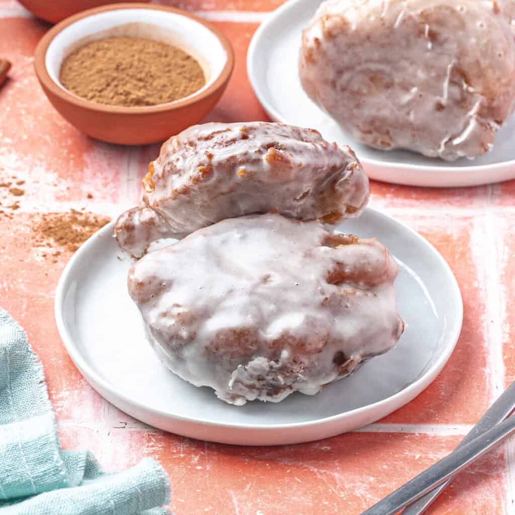 two apple fritters on a plate