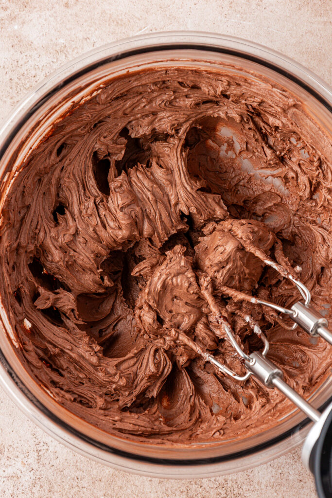 chocolate frosting in a bowl with two beaters