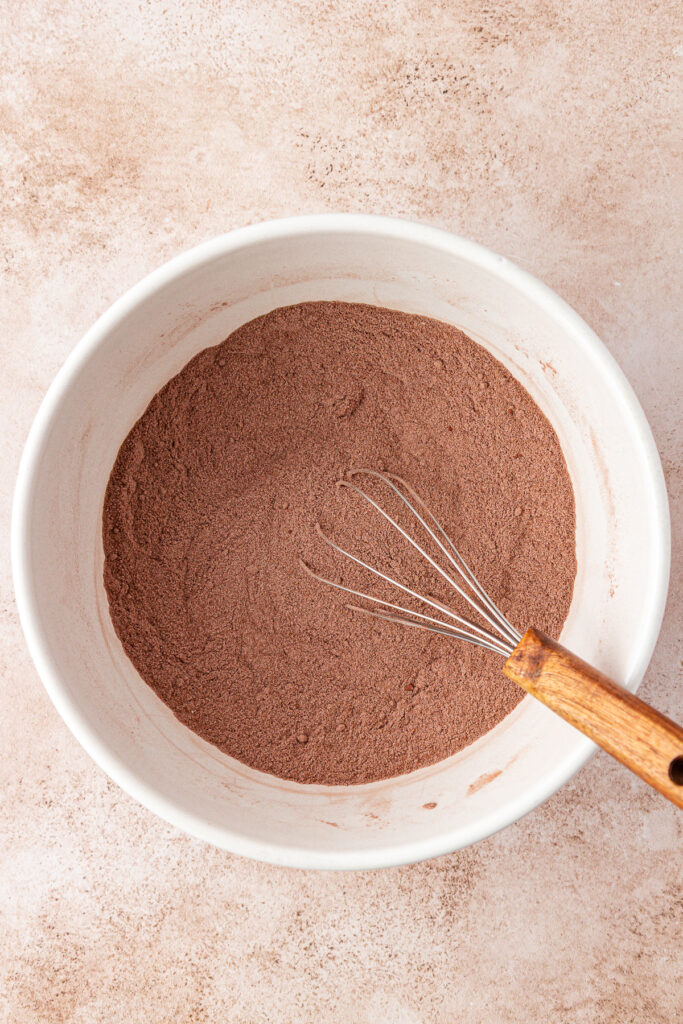 chocolate cake dry ingredients in a bowl with a whisk