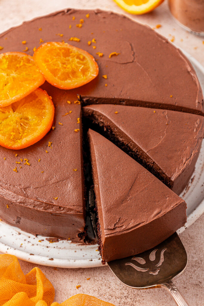 whole chocolate orange cake with two slices cut