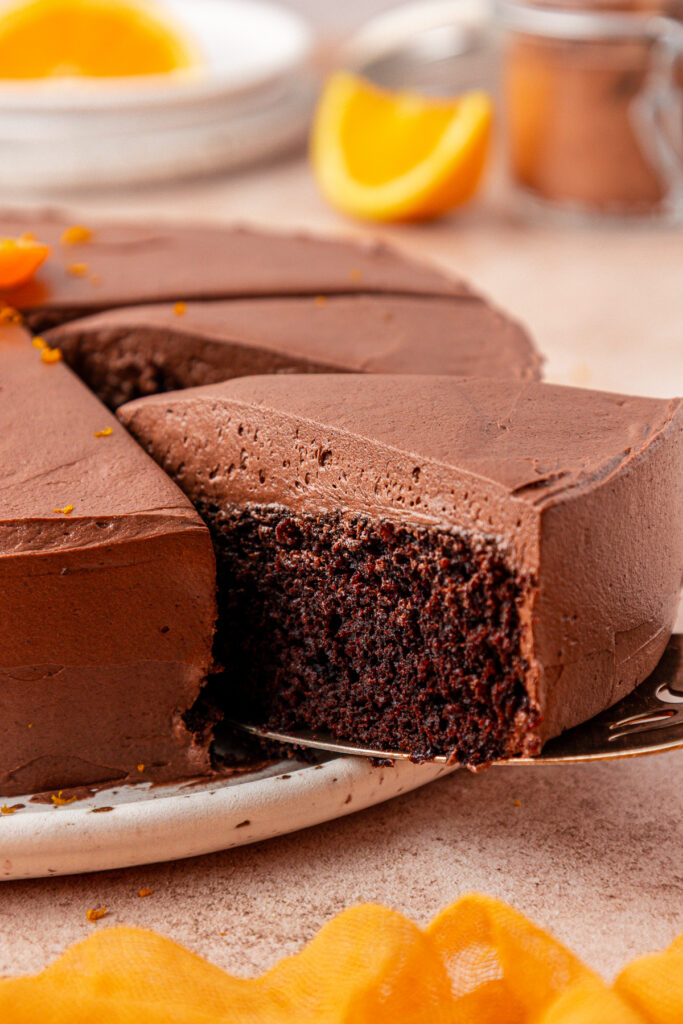 slice of chocolate orange cake being removed from the whole cake