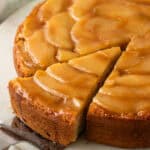 whole apple upside-down cake with a slice being removed