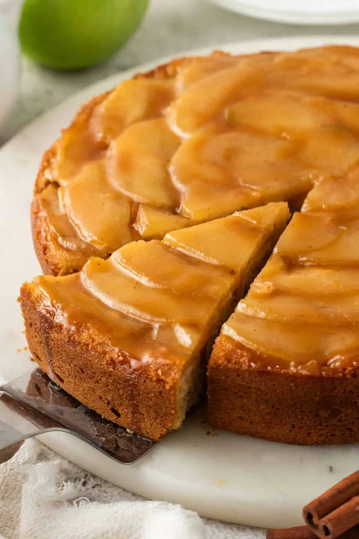 whole apple upside-down cake with a slice being removed