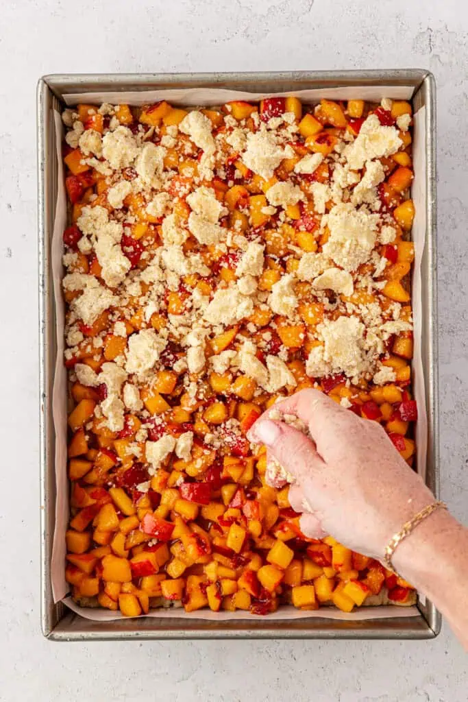 crumble mixture scattered over the top of the peaches