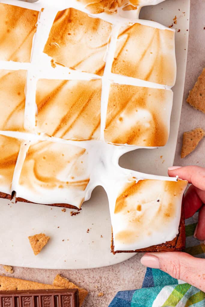 hand pulling a smores brownie away from the rest of the brownies