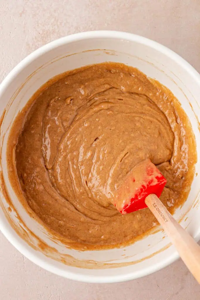 apple cider donut batter in a bowl with a spatula