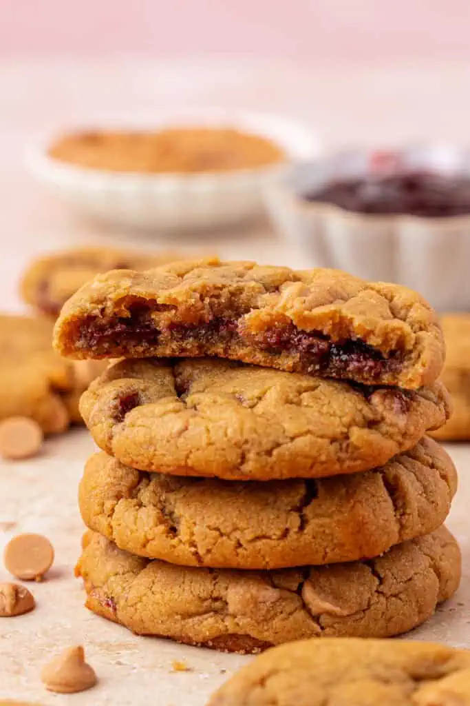 four peanut butter and jelly cookies stacked
