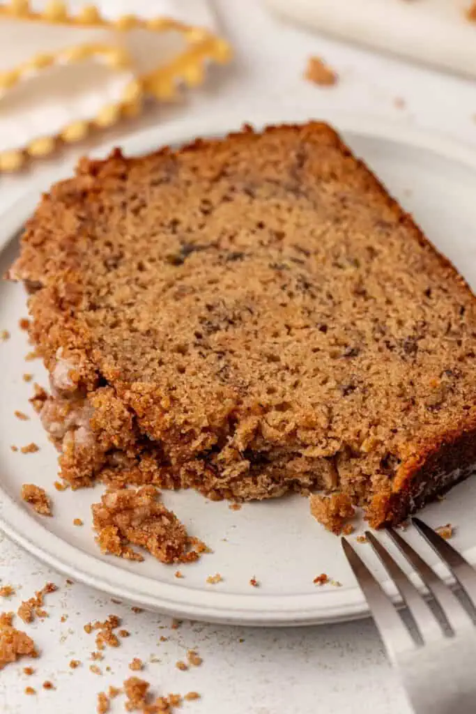 slice of browned butter banana bread on a plate cut with a fork