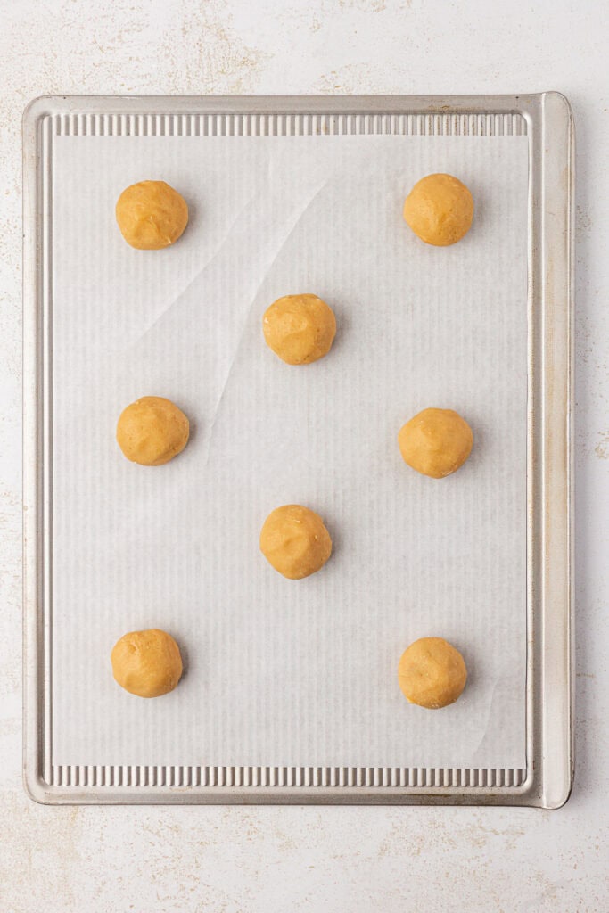 cookie dough balls on a cookie sheet