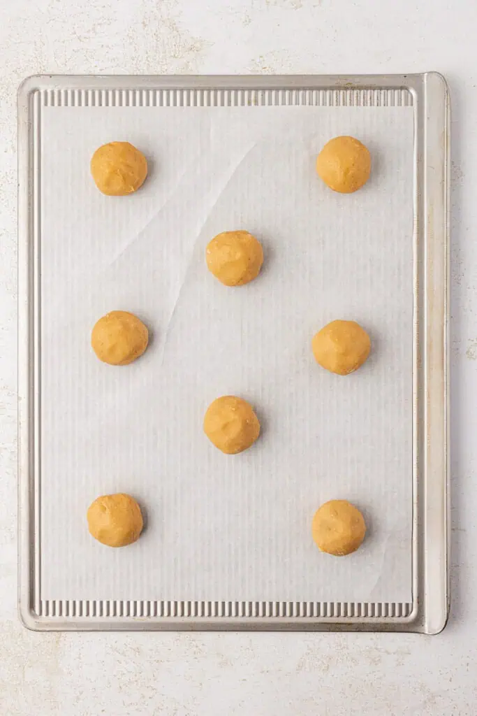 cookie dough balls on a cookie sheet