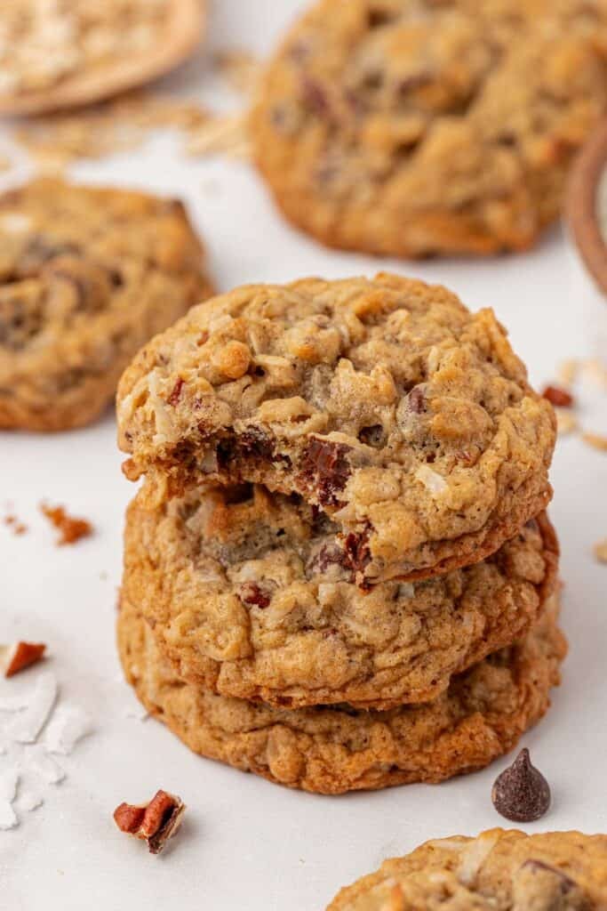 three cowboy cookies stacked with a bite taken out of it