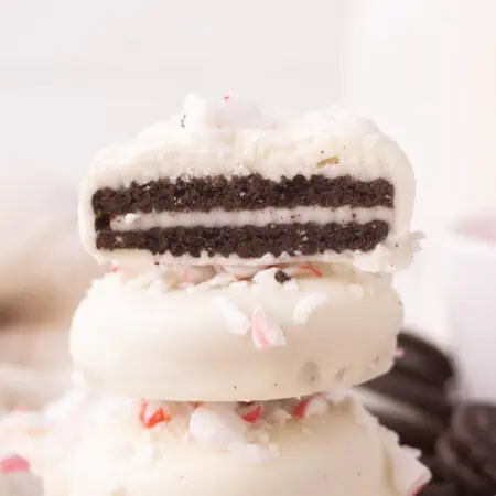three peppermint bark oreos stacked with top oreo cut in half