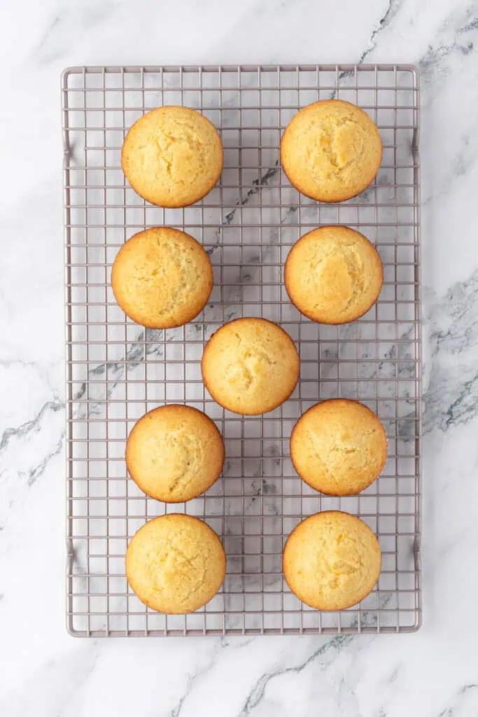 baked orange muffins on a wire rack