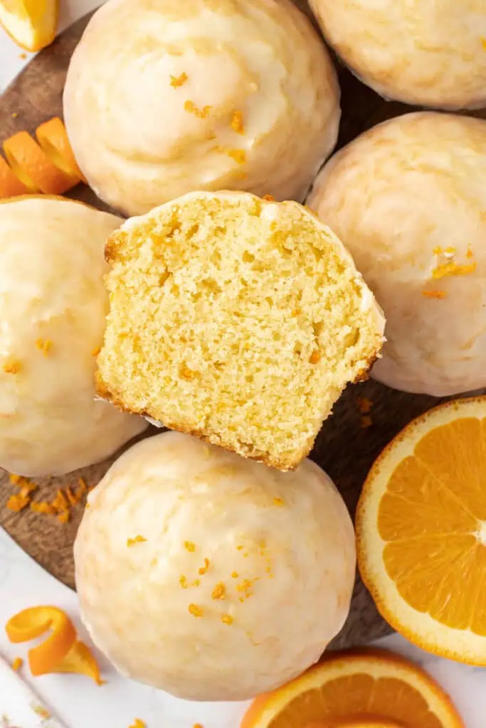 a bunch of orange muffins with one cut in half