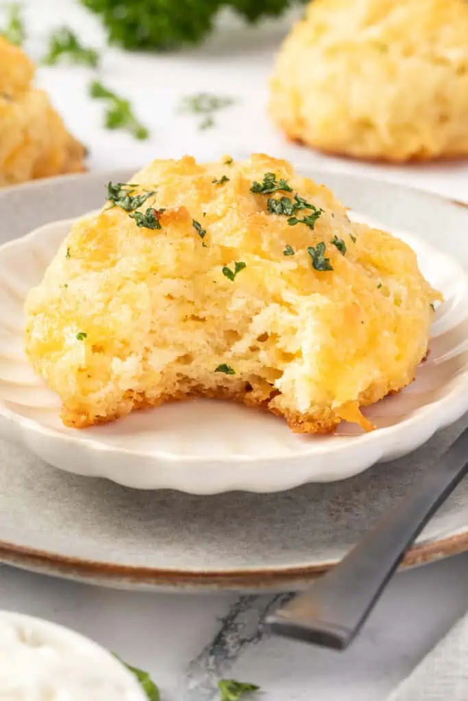 cheddar bay biscuit on a plate with a bite missing