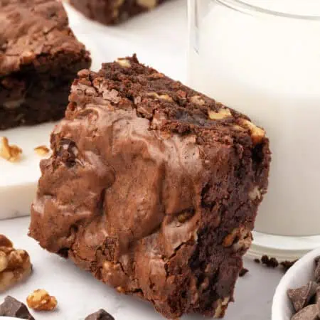 walnut brownie leaning against a glass of milk