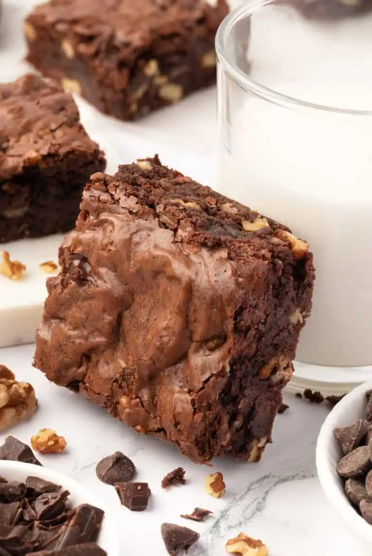 walnut brownie leaning against a glass of milk