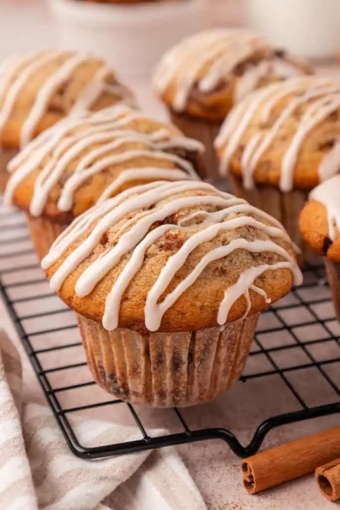 cinnamon roll muffin iced on a wire rack