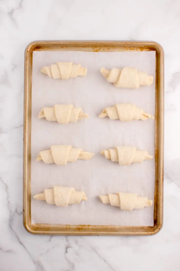 croissants rising on a cookie sheet