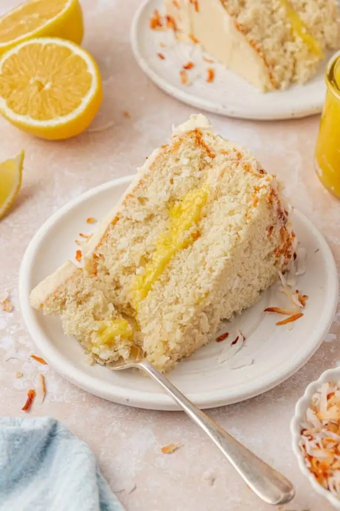 slice of lemon coconut cake on a plate with a fork