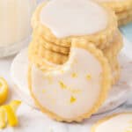 A lemon shortbread cookie leaning against a stack of cookies