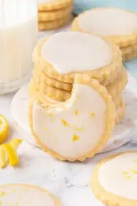 A lemon shortbread cookie leaning against a stack of cookies