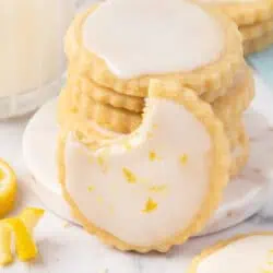 A lemon shortbread cookie leaning against a stack of cookies