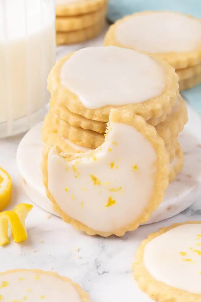 A lemon shortbread cookie leaning against a stack of cookies