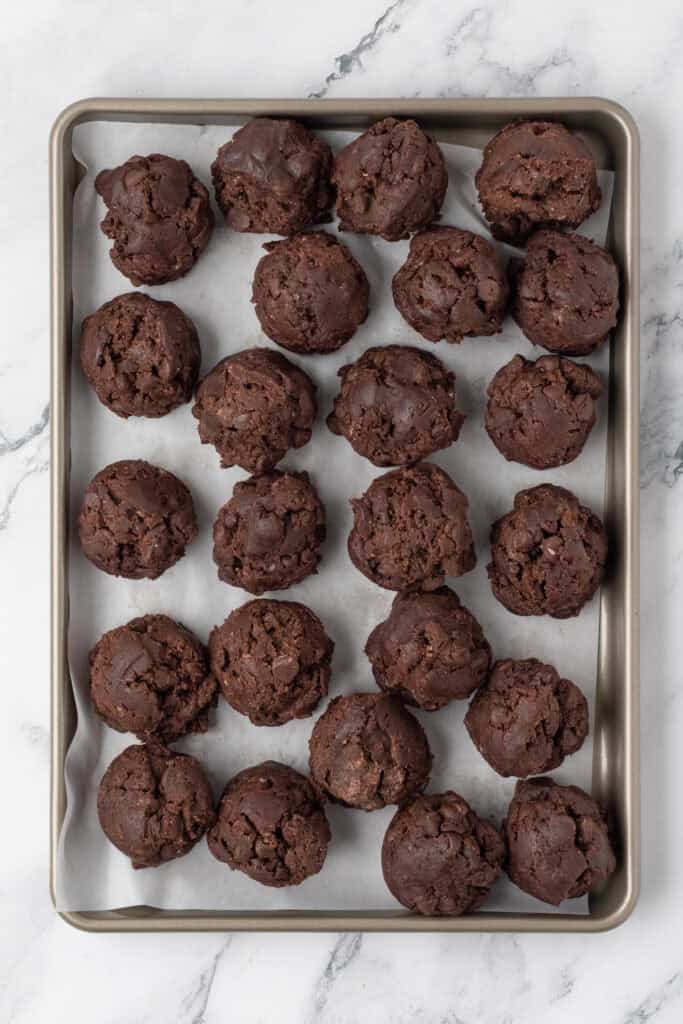 cookie dough balls on a cookie sheet