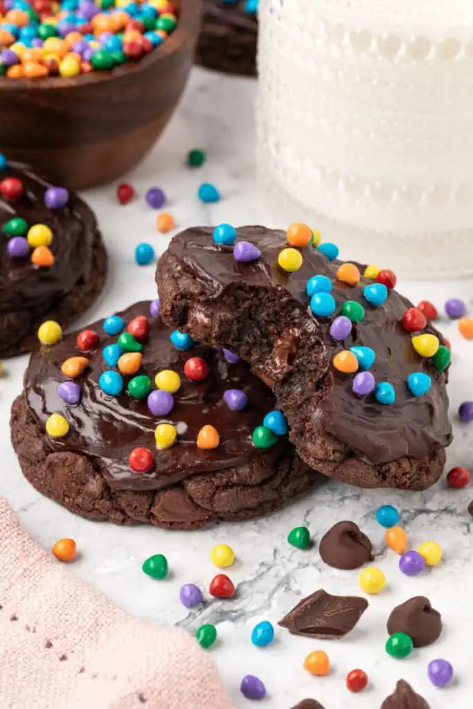 two cosmic brownie cookies slightly stacked on each other with one having a bite taken out of it