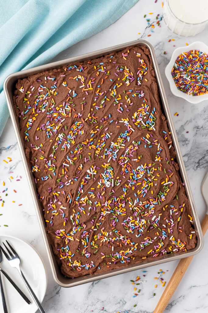 pan of cake with frosting and sprinkles on top