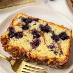 slice of blueberry cinnamon bread on a plate with a fork