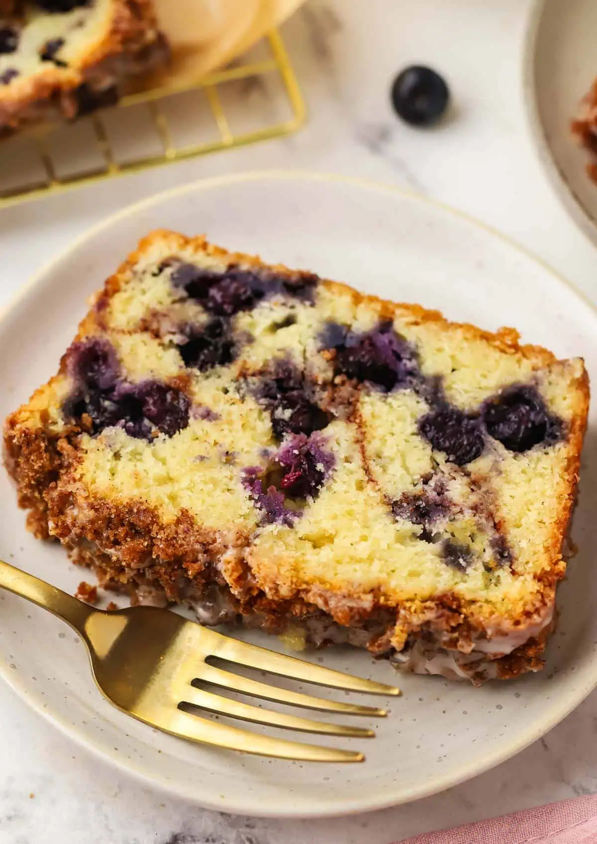 slice of blueberry cinnamon bread on a plate with a fork