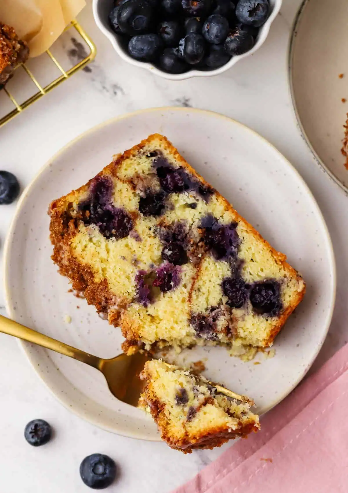 a slice of blueberry cinnamon bread on a plate with a fork