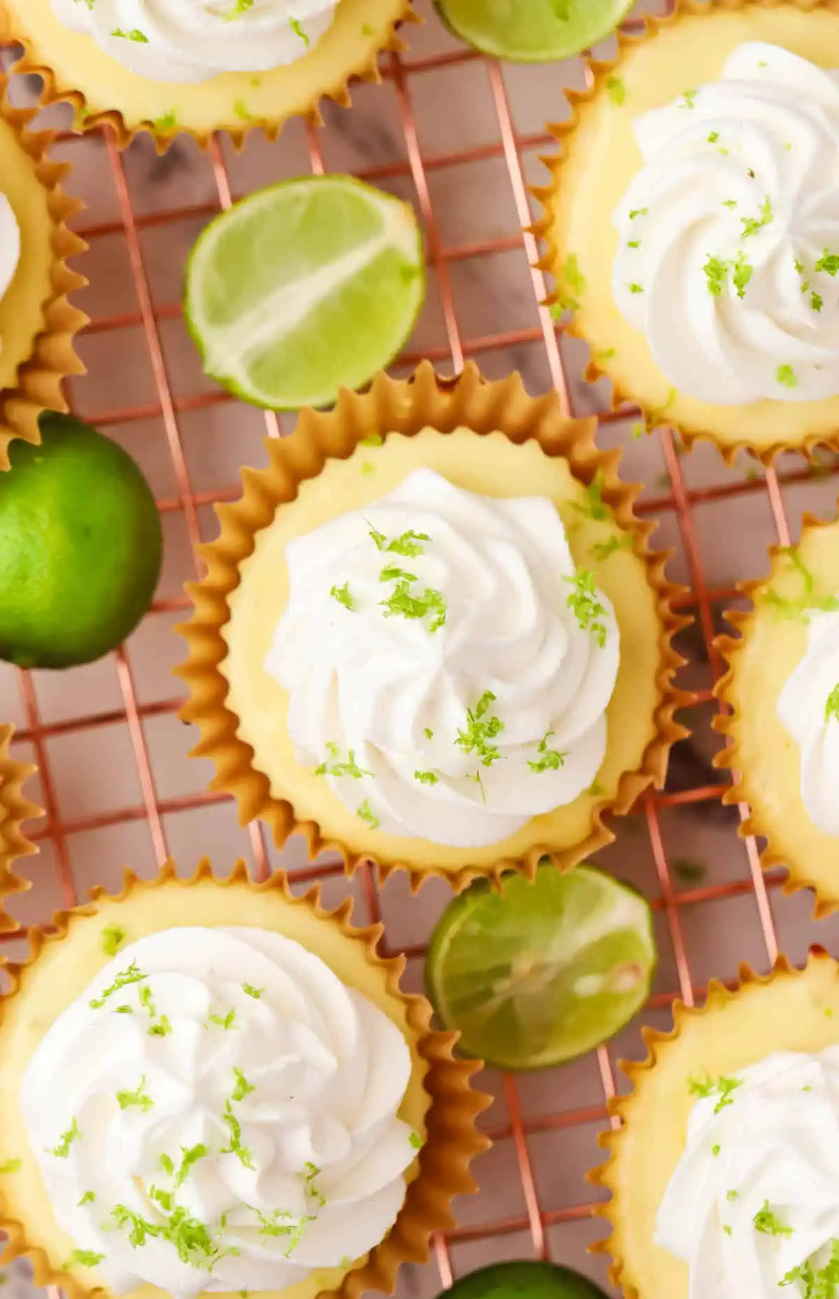 key lime pies topped with whipped cream on a wire rack
